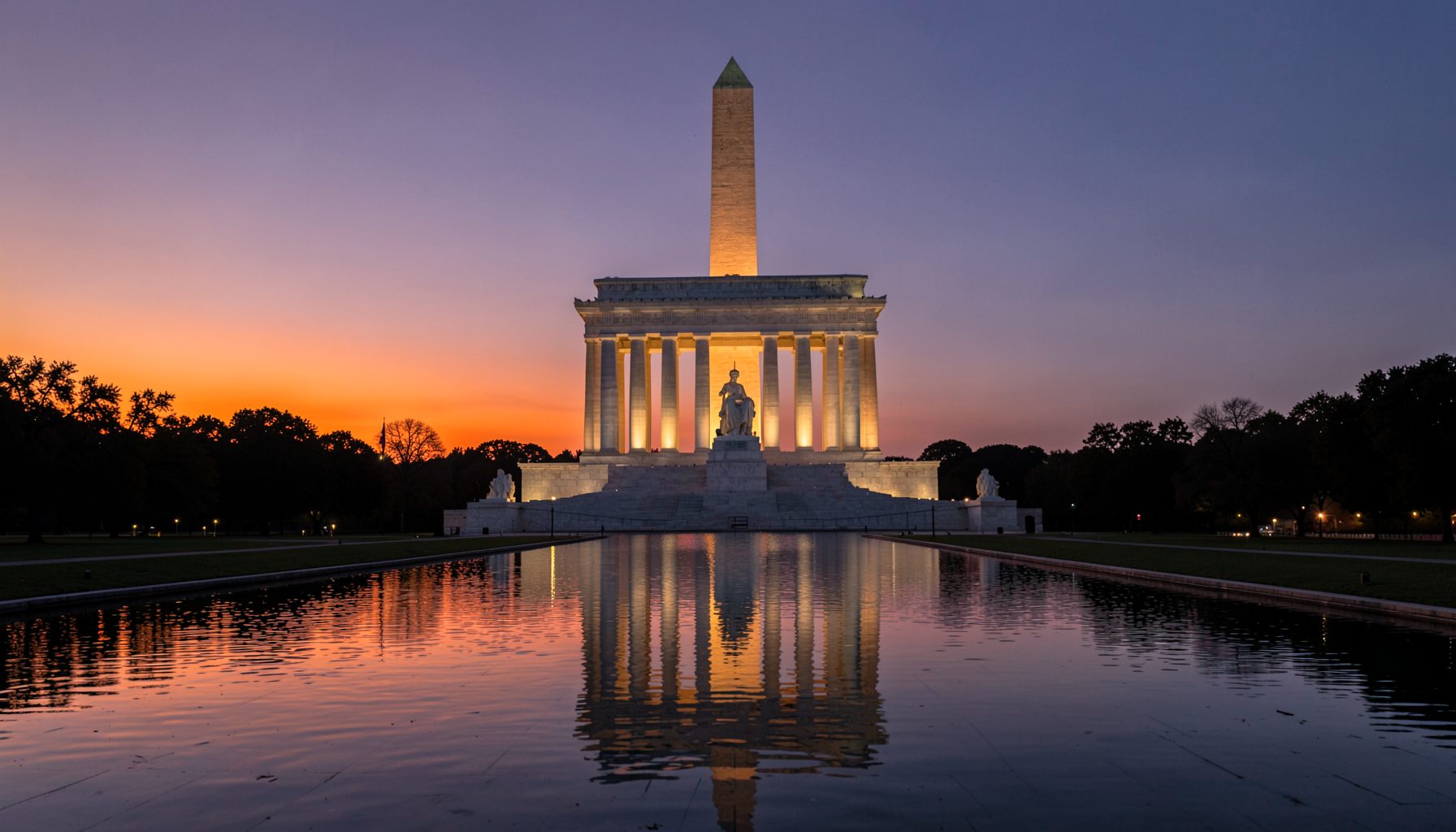 The Lincoln Memorial in Washington DC at dusk, with the seated statue illuminated and reflecting pool stretching toward the Washington Monument