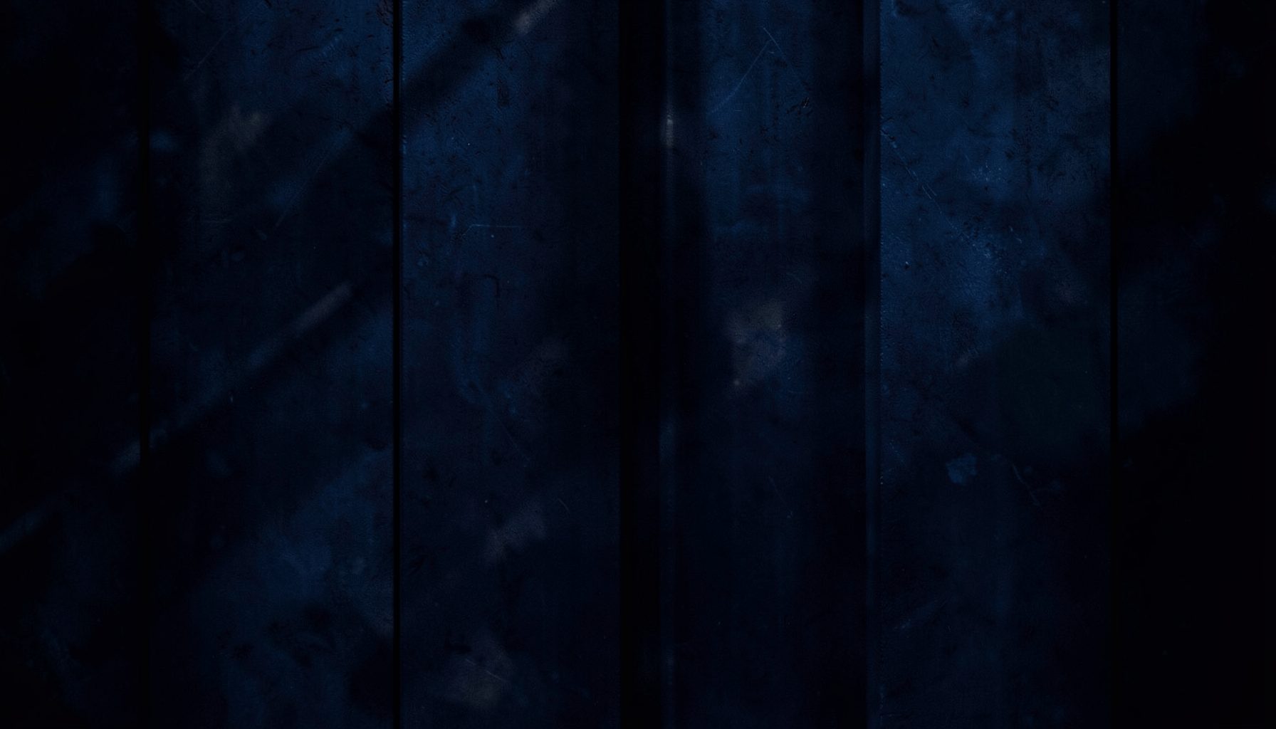 Deep indigo and charcoal abstract texture with subtle light streaks, nocturnal mood